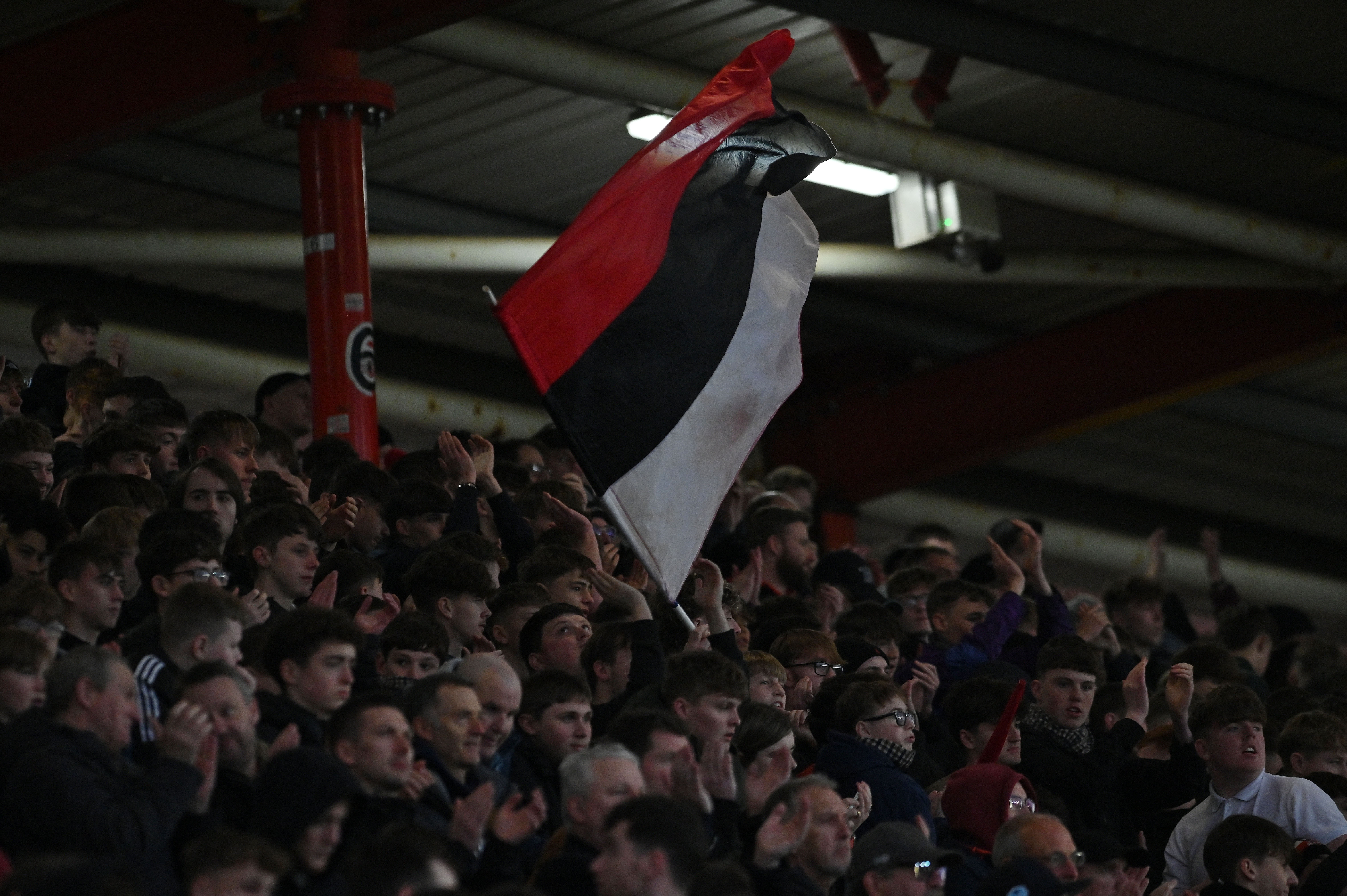 An image of the Big Bank at St James Park with a red, black and white striped flag